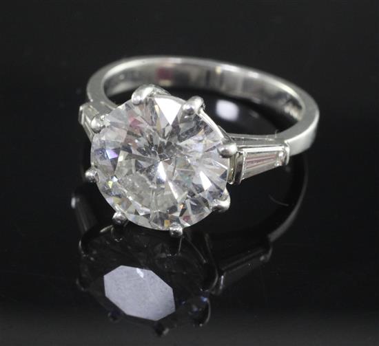 An attractive modern platinum and single stone diamond ring with trapeze cut diamond set shoulders, size K.